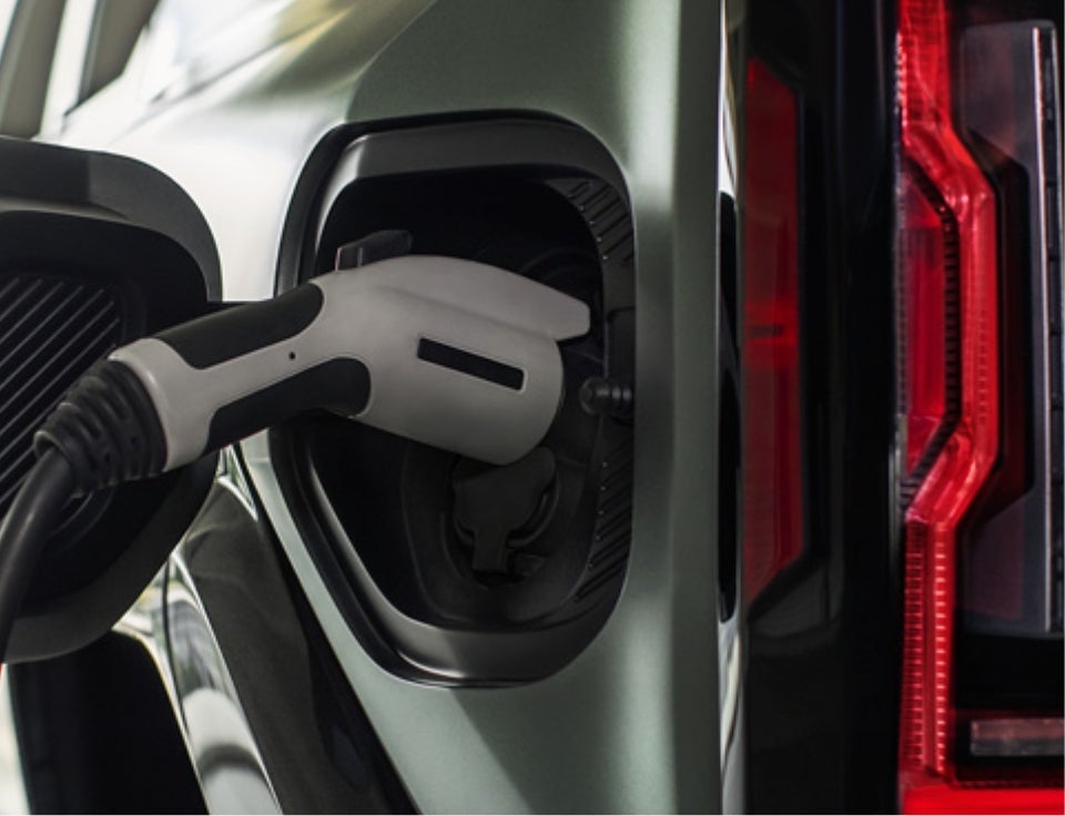 Close up of charging port with charger plugged in on a GMC Hummer EV SUV - Ervin Motor Co in VINTON IA